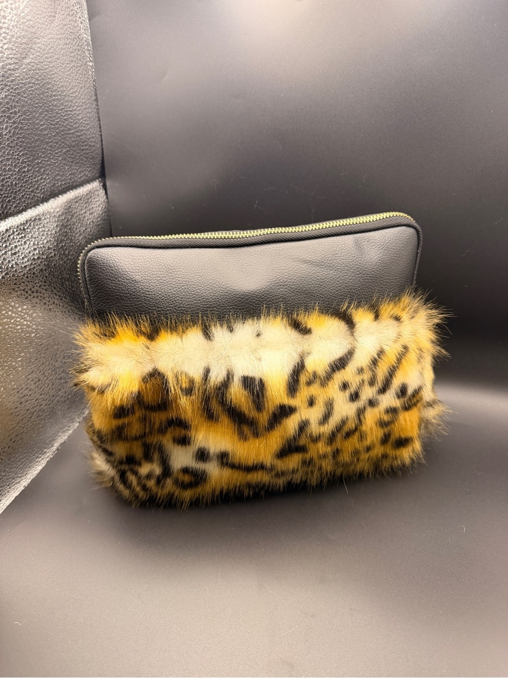 faux fur cheetah print clutch bag featuring a black zipper